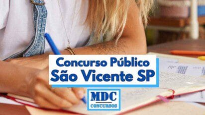 Imagem de uma pessoa escrevendo com uma caneta azul sobre um caderno aberto, com vários papéis de estudo espalhados sobre uma mesa, sugerindo um ambiente de preparação para provas. A pessoa usa uma camiseta branca e um macacão jeans, e possui cabelo loiro. Em destaque, há uma faixa branca com borda azul contendo o texto Concurso Público São Vicente SP e o logotipo da MDC Concursos