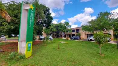 Processos Seletivos 2 Vista externa da Secretaria de Estado de Educação de Mato Grosso do Sul com placa vertical verde, área gramada, árvores e carros estacionados diante do prédio. Foto: Divulgação/SED-MS
