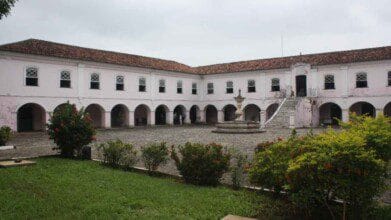 Processos Seletivos 3 Prédio histórico do Arquivo Público do Estado da Bahia, em Salvador, com fachada rosa e pátio interno com fonte; é gerido pela Fundação Pedro Calmon – FPC
