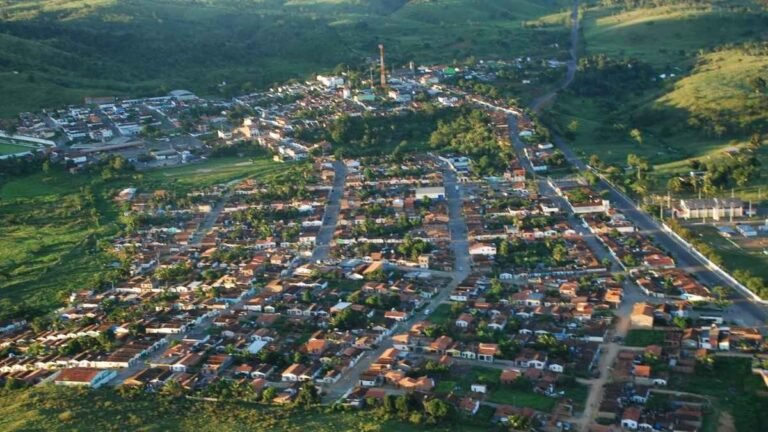 Vista aérea da cidade de Itagibá, mostrando ruas organizadas, casas com telhados avermelhados, áreas verdes e morros ao redor. Foto: Divulgação/Prefeitura de Itagibá-BA