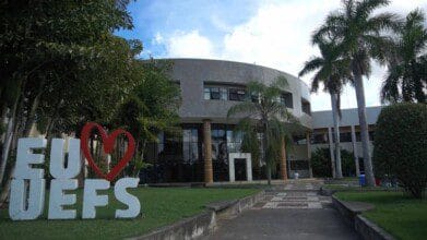 Prédio da UEFS com jardim e escultura escrita “EU ❤️ UEFS” em destaque na entrada. Foto: Divulgação/UEFS