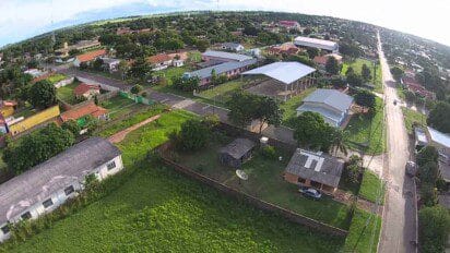 Vista aérea da cidade de Caracol-MS com destaque para ruas asfaltadas, prédios públicos, áreas residenciais e vegetação.