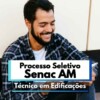 Homem jovem de barba e cabelos escuros está sentado ao ar livre, sorrindo enquanto segura um tablet. Ele veste uma camisa xadrez e camiseta branca. Ao fundo, há uma parede clara com detalhes escuros. Na imagem há um banner com os dizeres “Processo Seletivo Senac AM Técnico em Edificações”, indicando uma oportunidade de vaga no estado do Amazonas.