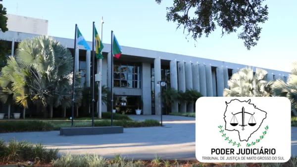 Fachada do Tribunal de Justiça de Mato Grosso do Sul com bandeiras hasteadas, área ajardinada e logomarca do Poder Judiciário do MS em destaque. Foto: Montagem MDC Concursos/Divulgação/TJMS