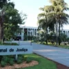 Fachada do prédio do Tribunal de Justiça de Mato Grosso do Sul em meio a jardins e palmeiras, com placa de identificação na entrada. Foto: Divulgação/TJMS