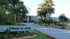 Fachada do prédio do Tribunal de Justiça de Mato Grosso do Sul em meio a jardins e palmeiras, com placa de identificação na entrada. Foto: Divulgação/TJMS