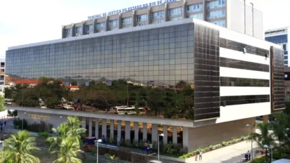 Fachada espelhada do prédio do Tribunal de Justiça do Estado do Rio de Janeiro com árvores e ônibus refletidos nas janelas. Foto: Divulgação/TJRJ