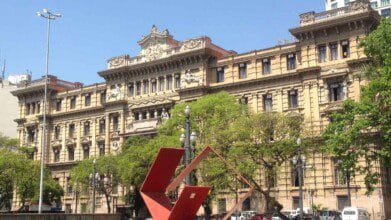 Fachada do prédio histórico do Tribunal de Justiça de São Paulo com esculturas, árvores e escultura vermelha em praça ao centro. Foto: Catherine Gaspar/Wikipédia