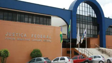 Fachada da Justiça Federal em Rondônia com o nome Fórum Ministro Jarbas Nobre e bandeiras hasteadas na entrada. Foto: Divulgação/TRF1