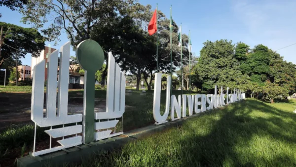 UEL abre 300 vagas de especialização em Treinamento Esportivo (EaD) 5 Letreiro da Universidade Estadual de Londrina em área verde do campus com árvores e mastros de bandeiras ao fundo. Foto: Divulgação/UEL