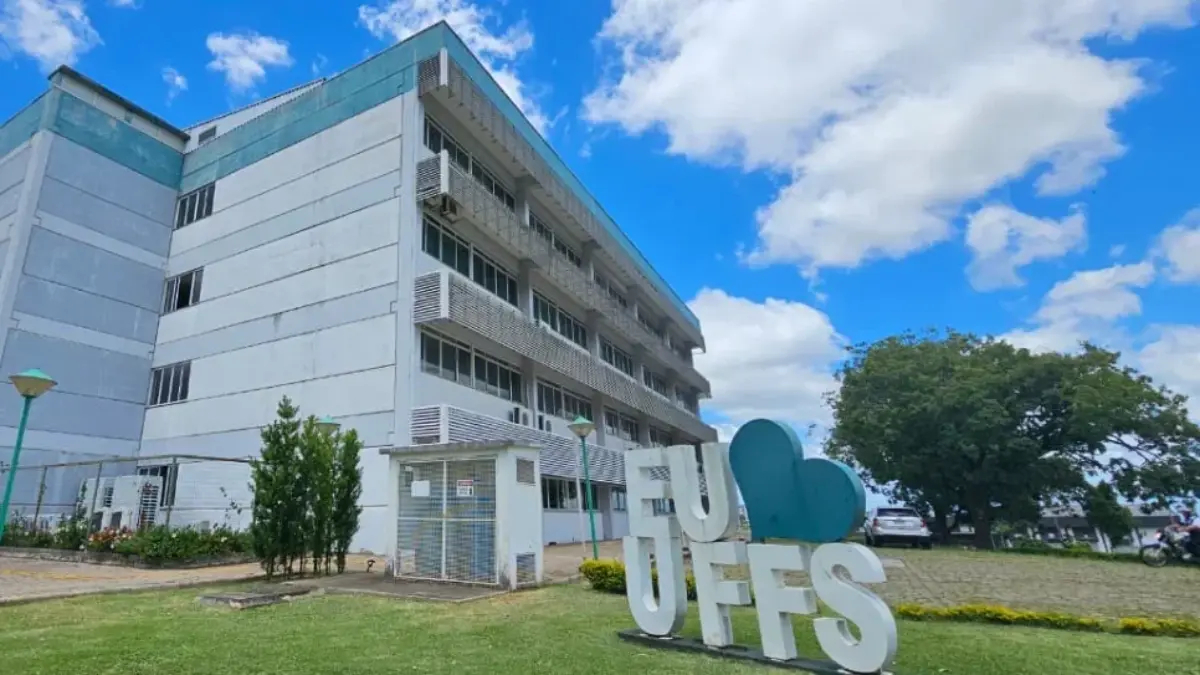 UFFS abre concurso com salários de até R$ 6.142,04 para TAE 1 Fachada de um prédio da UFFS com vários andares sob um céu azul com nuvens. Em destaque no gramado, há um letreiro branco onde se lê "EU ❤️ UFFS".