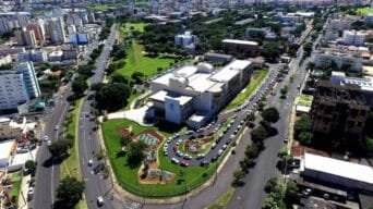 Vista aérea do prédio principal da Universidade Federal de Uberlândia (UFU), Campus Santa Mônica, cercado por vias urbanas, jardins e área residencial.