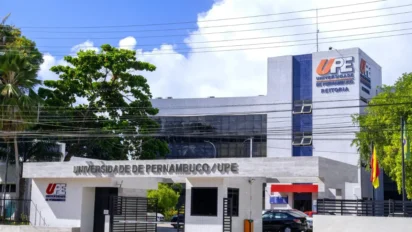 Fachada da Reitoria da Universidade de Pernambuco (UPE), um prédio moderno revestido com pastilhas brancas e detalhes em azul, apresentando o letreiro da instituição na entrada principal e no topo da edificação. Foto: Divulgação/UPE