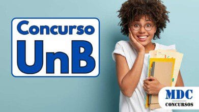 Jovem sorridente de óculos redondos com cabelo crespo volumoso, vestindo camiseta branca, segura cadernos, pastas e papéis coloridos contra o peito com uma mão enquanto apoia o rosto na outra, em frente a um fundo azul claro - UnB oferece 273 vagas e salários de até R$ 4,9 mil em Concurso Público