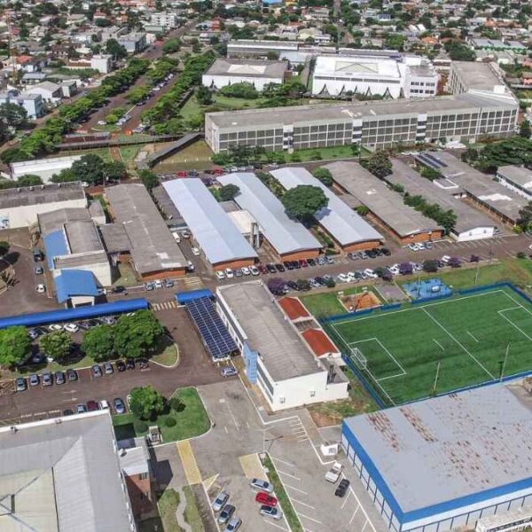 Vista aérea de um campus universitário da Unioeste Cascavel com prédios, estacionamentos, área verde e um campo de futebol cercado por rede. Foto: Divulgação/Unioeste
