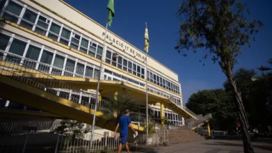 Volta Redonda abre processo seletivo com 18 vagas imediatas na Educação 2 Fachada do Palácio 17 de Julho, sede da Prefeitura de Volta Redonda, com bandeiras hasteadas e uma pessoa caminhando em frente ao prédio em dia ensolarado. Foto: Divulgação/Prefeitura de Volta Redonda-RJ